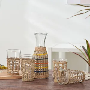 Woven glass water jug and cups set with natural rattan sleeve for home and hotel use.