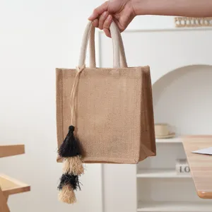 Detailaufnahme einer handgefertigten Strohtasche mit feiner Struktur und Quaste.