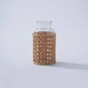 Handmade glass vase with woven rattan cover, retro rustic tabletop floral decor for home and homestay.
