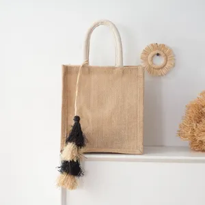 Detailansicht der handgemachten Strohtasche mit strukturierter Jute und schicker Quaste.