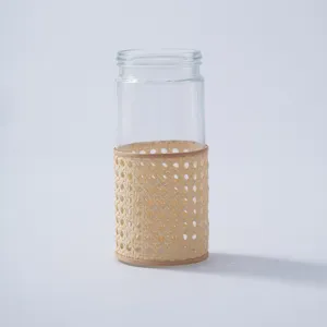 Detail shot of handmade rattan woven glass vase, perfect for desktop decoration and dry flowers.