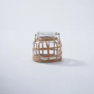 Glass bottle detail view with handmade woven straw net cover and metal handle.