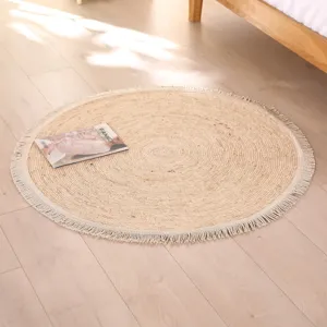 Close-up detail of a handmade woven round rug with tassel fringe in a cozy bedroom setting.