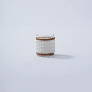 Handcrafted rattan glass vase detail shot showing woven texture and natural wood rim accents