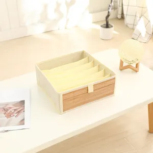 Close-up of the multi-compartment fabric storage box with bamboo front panel and neat grid dividers.