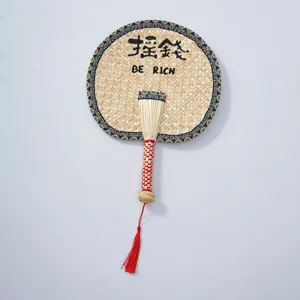 Handcrafted straw fan detail, traditional Chinese style woven fan with colorful border and red tassel.