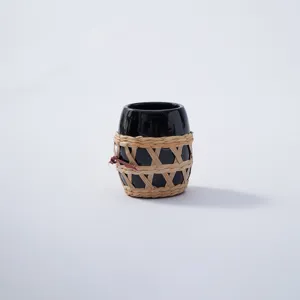 Handmade straw woven cup sleeve detail view, natural rattan bottle protector net wrap.