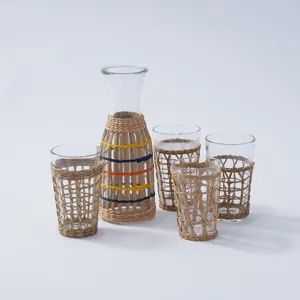 Handmade rattan woven glass pitcher and cup set, natural boho drinkware for home and hotel use.