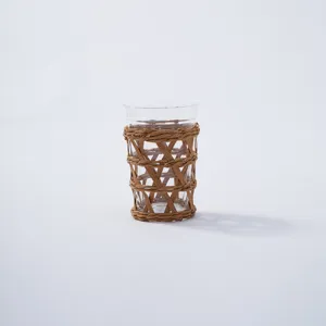 Detailed close-up of hand-woven rattan sleeve on clear glass cup, showing natural texture.