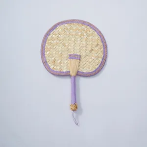 Handmade woven straw fan detail, natural plant fiber summer cooling fan with purple edge.