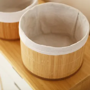 Round woven bamboo storage basket with white fabric liner, ideal for home desktop organization.