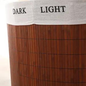 Vista detallada de la cesta de ropa de bambú con borde de tela oscuro y claro.