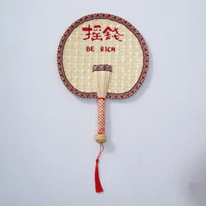 Handmade woven straw fan with red border tassel, traditional Chinese style cooling hand fan.