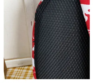 Toddler anti-lost backpack detail shot, breathable black mesh strap and red dinosaur pattern fabric.