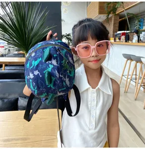 Cute dinosaur toddler backpack detail showing 3D spikes and anti-lost strap design.