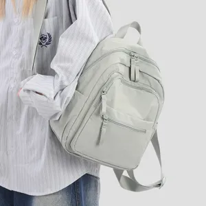 Lightweight waterproof nylon small backpack for women, casual travel daypack in stylish sage gray.