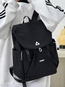 Detailed view of black casual Japanese style backpack on model showing front flap and pocket.
