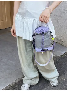 Detail view of the purple and grey outdoor lightweight shoulder bag, featuring drawstring and strap.
