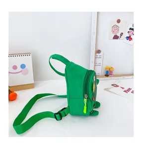 Vue de profil détaillée du sac de poitrine dinosaure vert pour enfants avec sangle et fermeture.