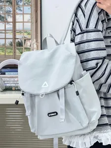 Detail view of casual minimalist light grey backpack showing front buckle and strap design.