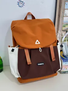 Colorblock casual backpack detail view, featuring durable fabric, multi-compartment design.