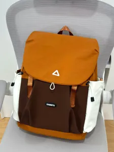 Color-block casual backpack detail view featuring drawstring pockets and flap closure.