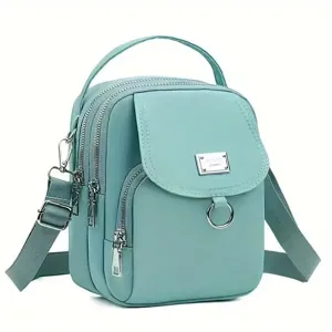 Vue détaillée du sac bandoulière en tissu oxford vert menthe avec plusieurs compartiments zippés.