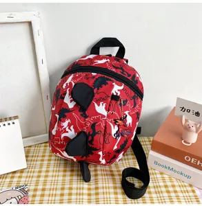 Detailed view of the cute toddler dinosaur anti-lost backpack in red with plush spikes.