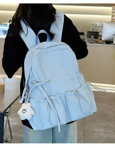 Light blue pleated school backpack with multiple pockets, bows, and cute plush pendant.