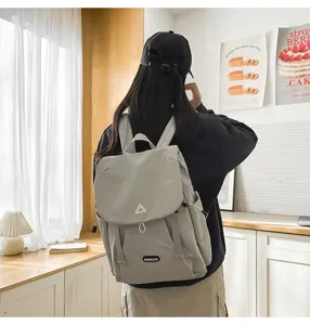 Detail view of casual large capacity travel backpack worn by model in room setting.