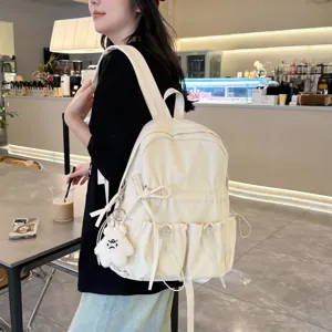 Stylish niche pleated backpack for women, lightweight casual school bookbag with cute bow decor.