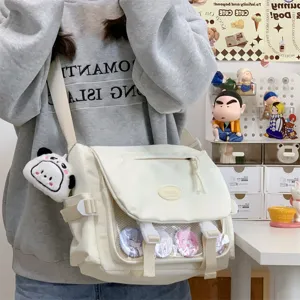 Detail view of Japanese college style canvas ita bag with transparent window and cute charm.