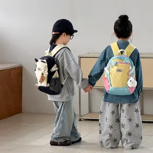 Detailansicht bunter Kinderrucksäcke mit süßen Plüschanhängern, leichte Taschen für draußen.