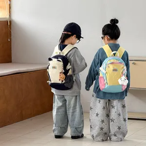 Detailansicht des bunten Kinderrucksacks mit Plueschanhaenger und praktischen Faechern.