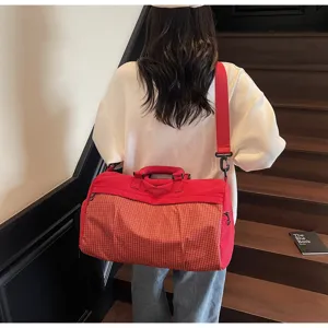 Detail view of women's red travel fitness bag, lightweight crossbody tote for short trips.