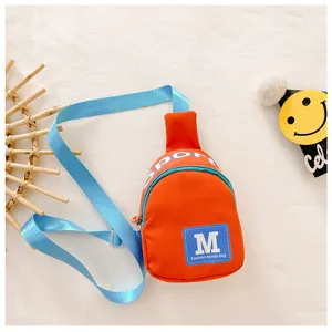 Close-up detail van de oranje crossbody borsttas voor kinderen met blauwe schouderbanden.