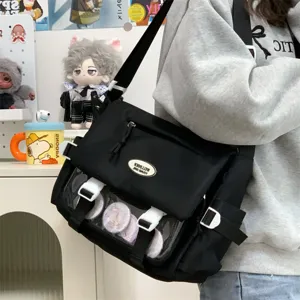 Details of black college style ita messenger bag with transparent window and cool anime badges.