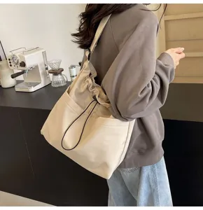 Detail view of stylish minimalist solid color nylon bucket bag with convenient drawstring design.