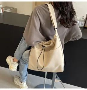 Casual nylon bucket shoulder bag detail, stylish drawstring design with front pocket for daily wear.