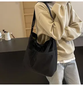 Black nylon shoulder bag detail view showcasing casual minimalist style and durable fabric.