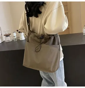 Casual nylon bucket bag with drawstring design and front pocket, perfect for daily casual use.