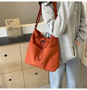 Casual solid color nylon bucket bag featuring a practical drawstring and daily shoulder strap.