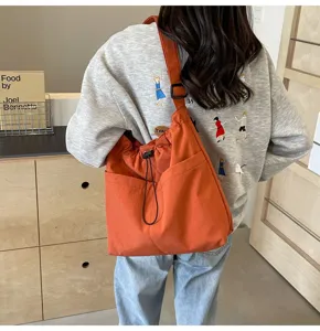 Stylish minimalist solid color nylon bucket bag with convenient drawstring and shoulder strap.