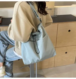 Casual solid color nylon bucket bag with drawstring closure and practical pockets detail