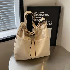 Minimalist solid color nylon bucket bag with a convenient drawstring design for casual use.