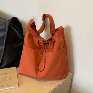 Orange nylon bucket bag, stylish casual shoulder bag with convenient drawstring design.