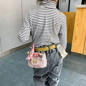 Detailed view of the pink tweed shoulder bag featuring cute rabbit charms and gold chain.