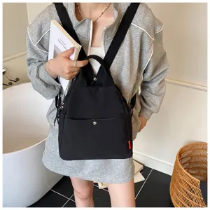Detailed view of black minimalist casual backpack, versatile daily commuting bag carried by model.