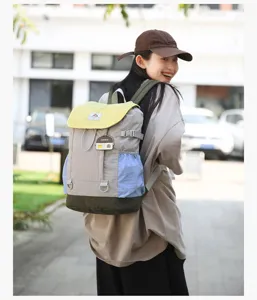Casual color block backpack detail showing vibrant yellow flap and blue side pockets.