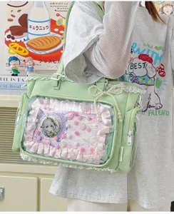 Detalle de bolso ita con ventana transparente, volantes de encaje y lazo de perlas.